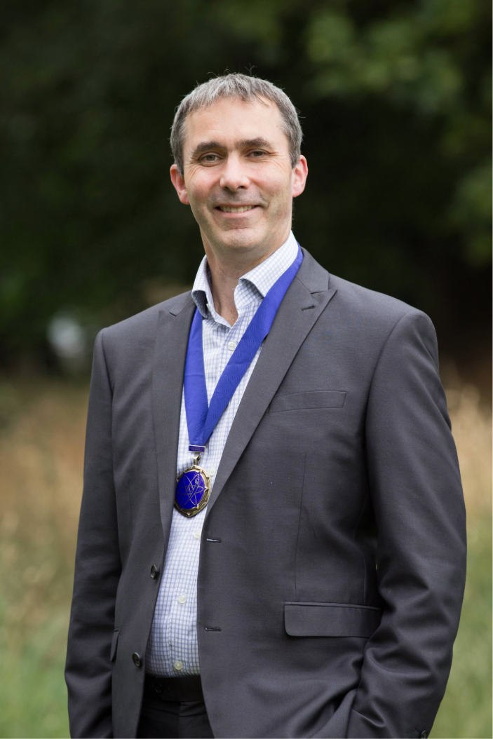 Mark Knight wears the IPEM President Medal in a portrait